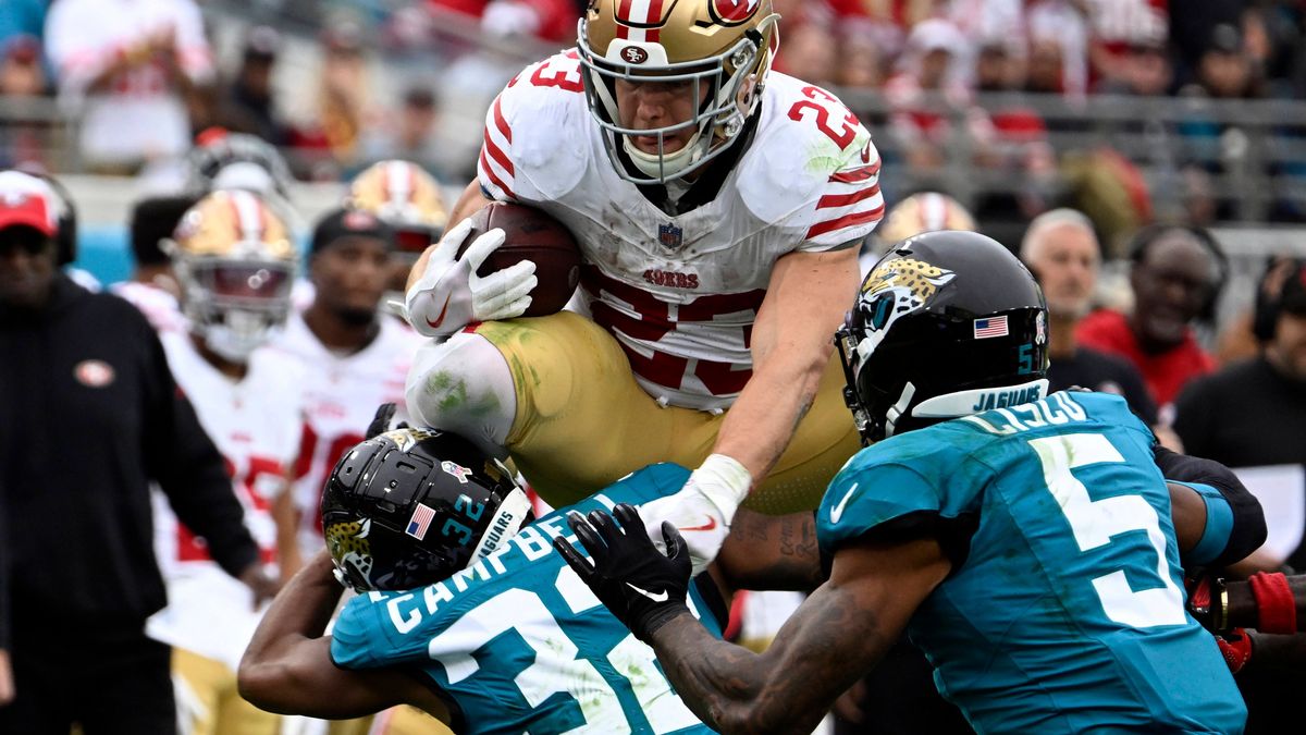 San Francisco Running Back Christian McCaffrey leaps over defenders as he runs for a short gain in the second quarter as the 49ers compete against the Jaguars at the EverBank Stadium in Jacksonvill...