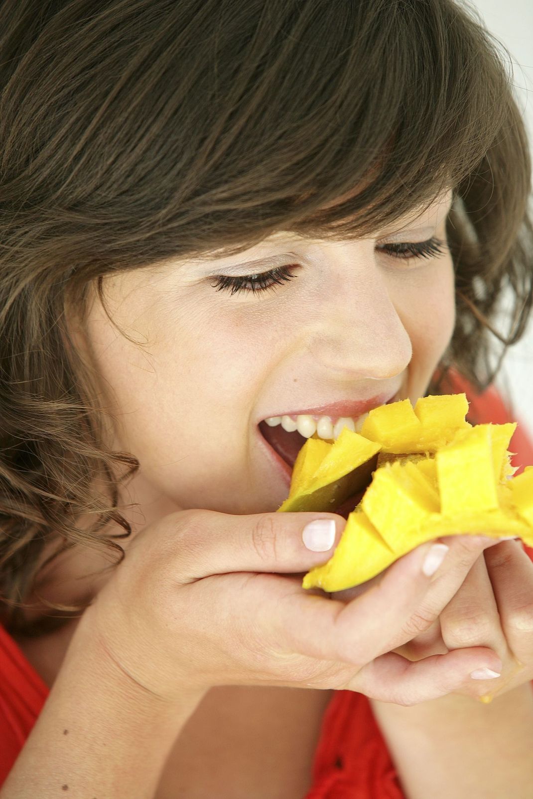 Wenn's mal schnell gehen muss, kannst du - statt mit einem Löffel oder einer Gabel - mit den Zähnen die Mango-Stückchen abbeißen.