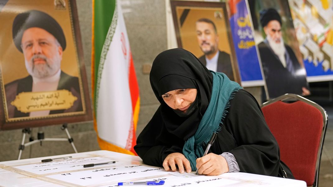 Eine Frau gibt ihre Stimme in einem Wahllokal in der iranischen Botschaft ab.