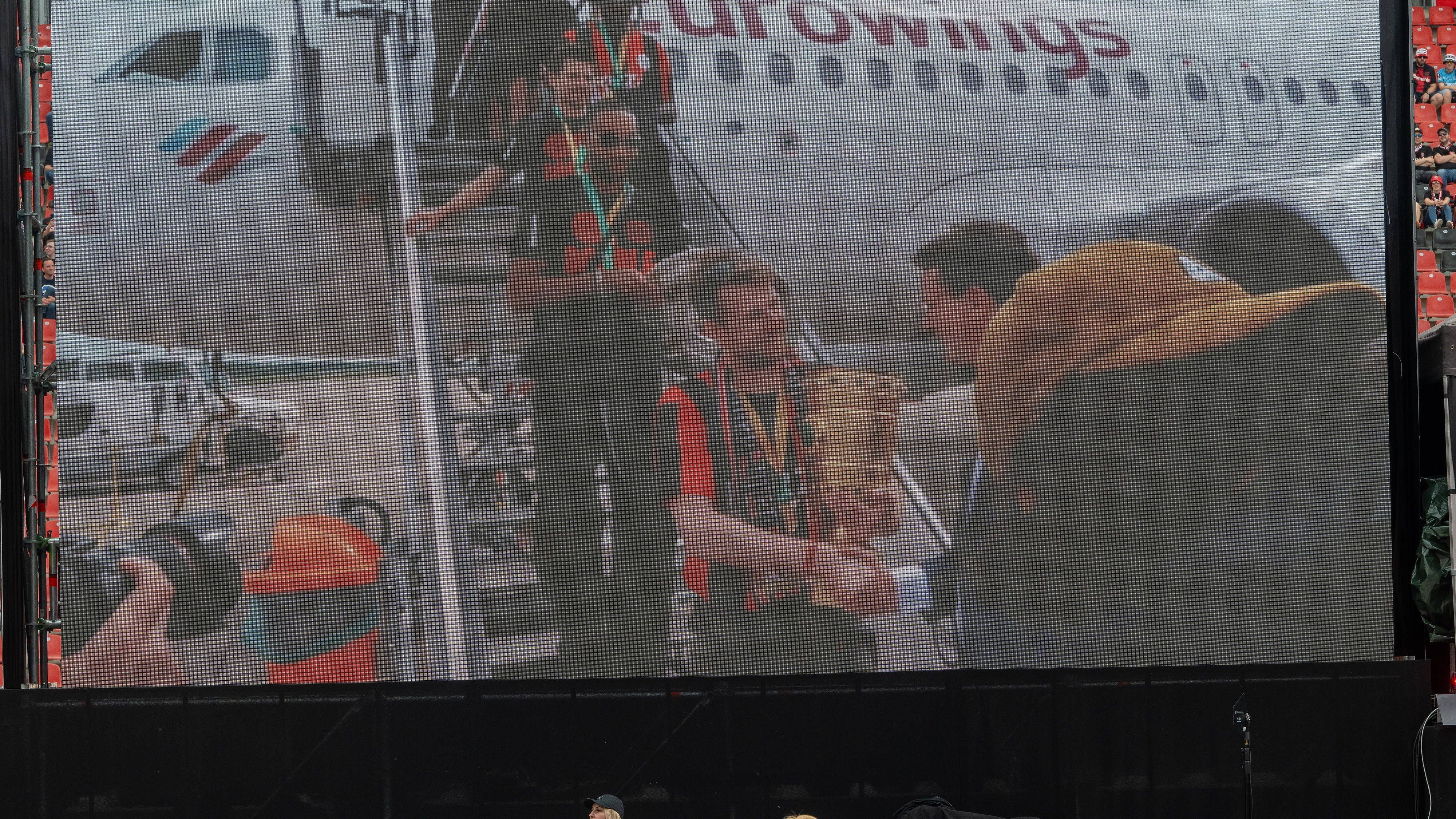 <strong>Bayer Leverkusen feiert den Double-Gewinn</strong><br>Der Double-Sieger ist gelandet! Am Flughafen Köln/Bonn startete die große Meisterfeier. Hendrik Wüst, Ministerpräsident des Landes Nordrhein-Westfalen, empfing die Bayer-Stars. All das war auf einer Leinwand in der BayArena zu sehen.