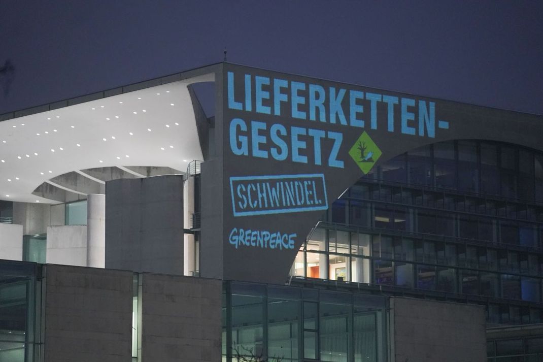 Bei einer Greenpeace-Aktion wurde "Lieferkettengesetz. Schwindel" an die Außenfassade des Bundeskanzleramts projiziert.