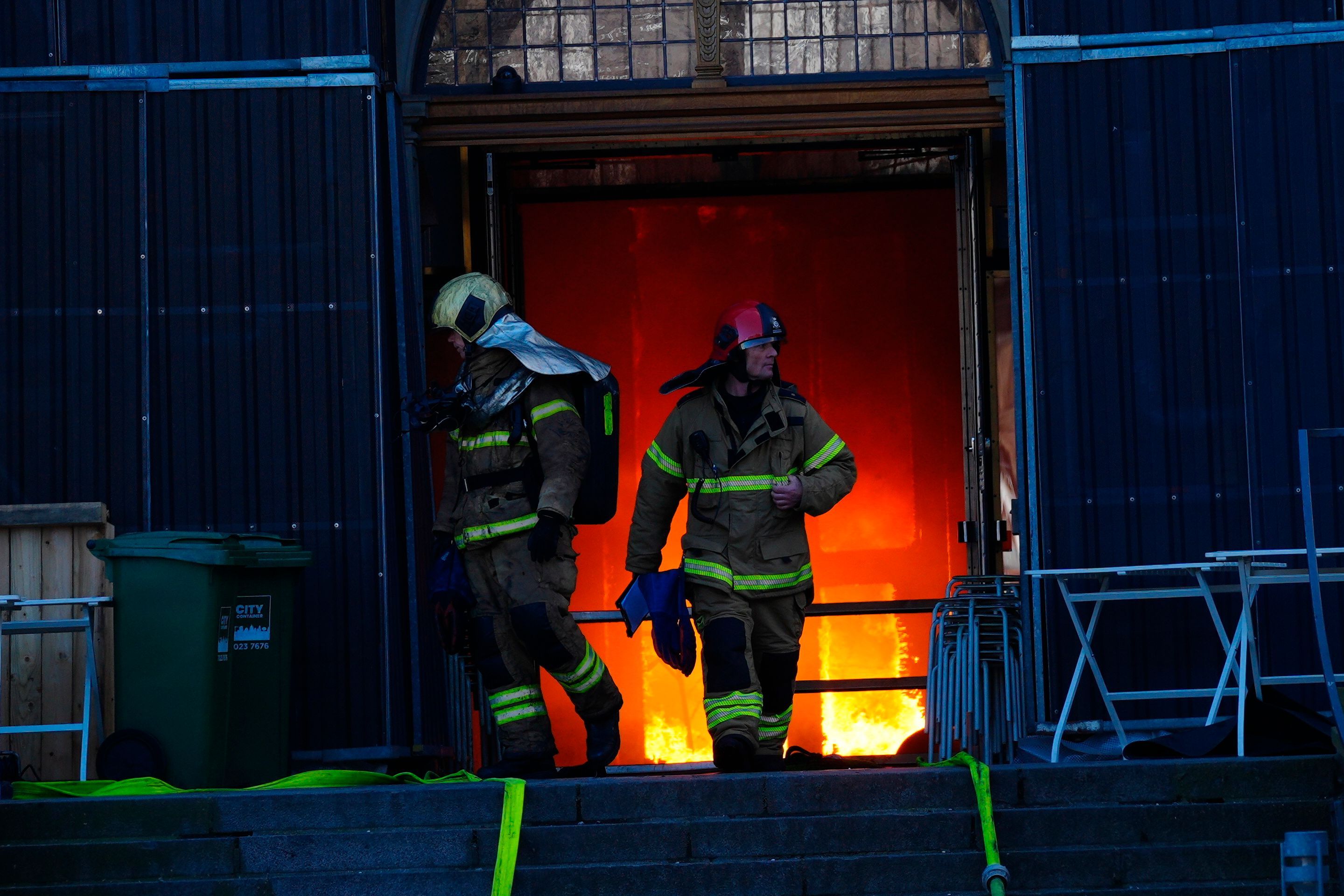 Feuerwehrleute verlassen den Haupteingang.