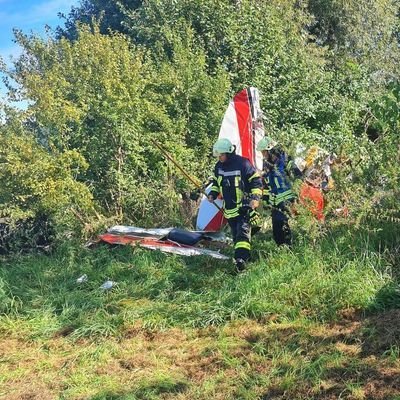 Helfer arbeiten an der Absturzstelle eines Kleinflugzeuges in Gütersloh.