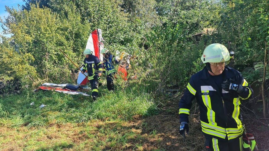 Helfer arbeiten an der Absturzstelle eines Kleinflugzeuges in Gütersloh.