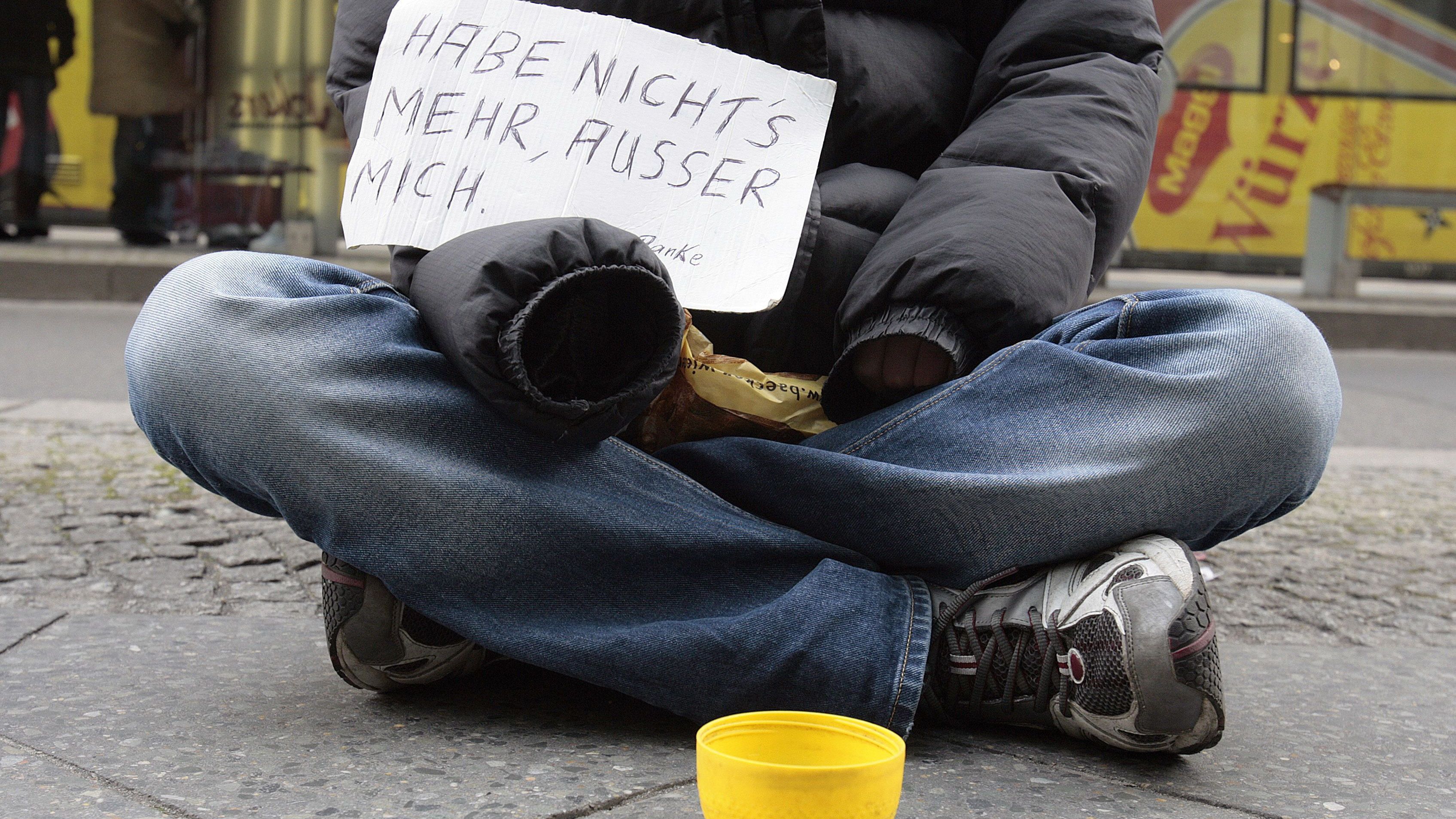 Ein Obdachloser sitzt mit einem Schild auf der Straße und bettelt. Erschreckend: Über 250.000 Menschen gelten in Deutschland als wohnungslos.&nbsp;