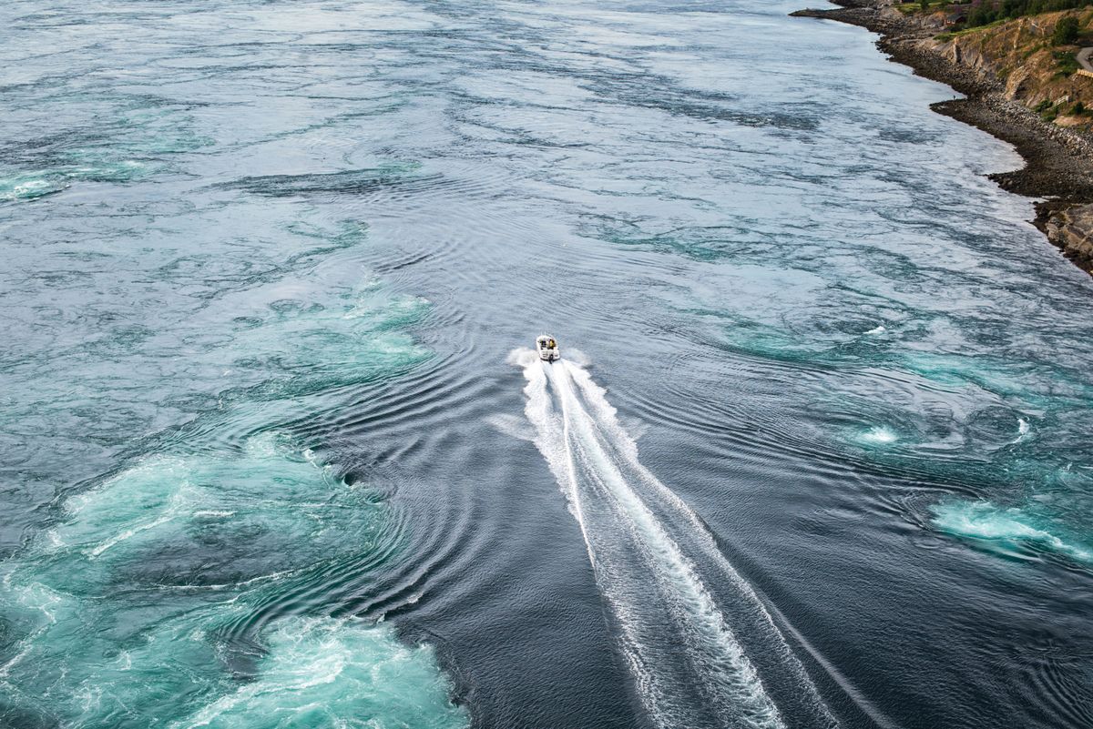 Eine Crew wagt mit einem Speedboot die Fahrt durch den Strom der Gezeiten in Norwegen. Dort bilden sich mehrere Wasserstrudel.