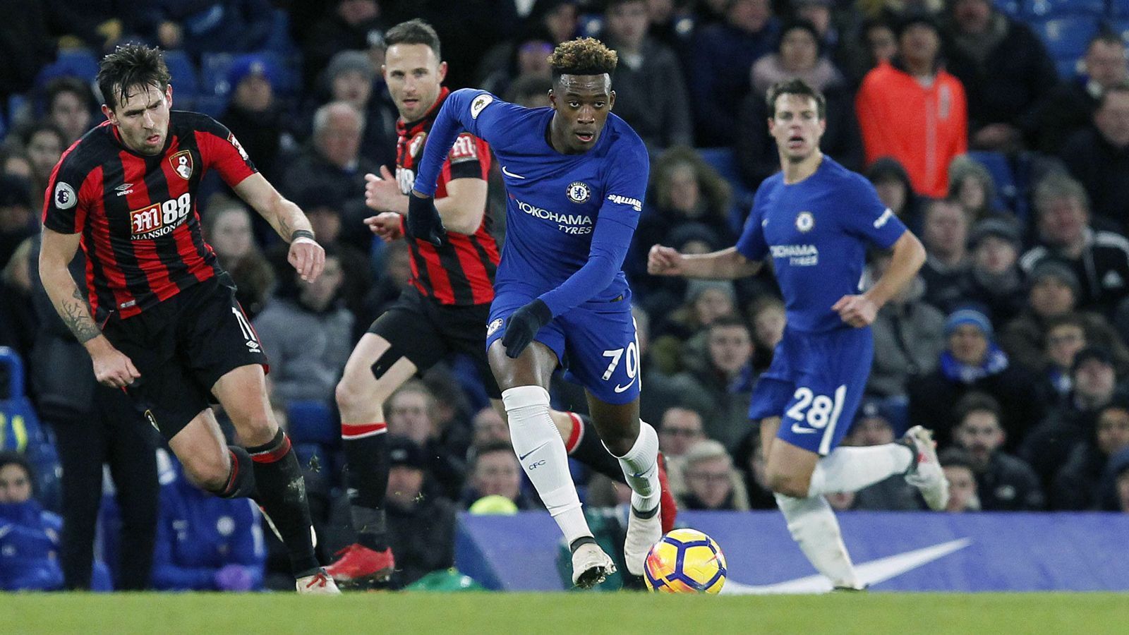 
                <strong>Debüt gegen Bournemouth</strong><br>
                Drei Tage nach dem Profi-Debüt kam Hudson-Odoi am 31. Januar 2018 zu seinem ersten Einsatz in der Premier League. Was für den Jungstar ein glücklicher Moment sein sollte, endete für Chelsea in einem Desaster. Der damals noch amtierende Meister verlor vor eigenem Publikum mit 0:3 gegen Underdog Bournemouth. Hudson-Odoi wurde in der 65. Minute für den Italiener Davide Zappacosta eingewechselt.
              