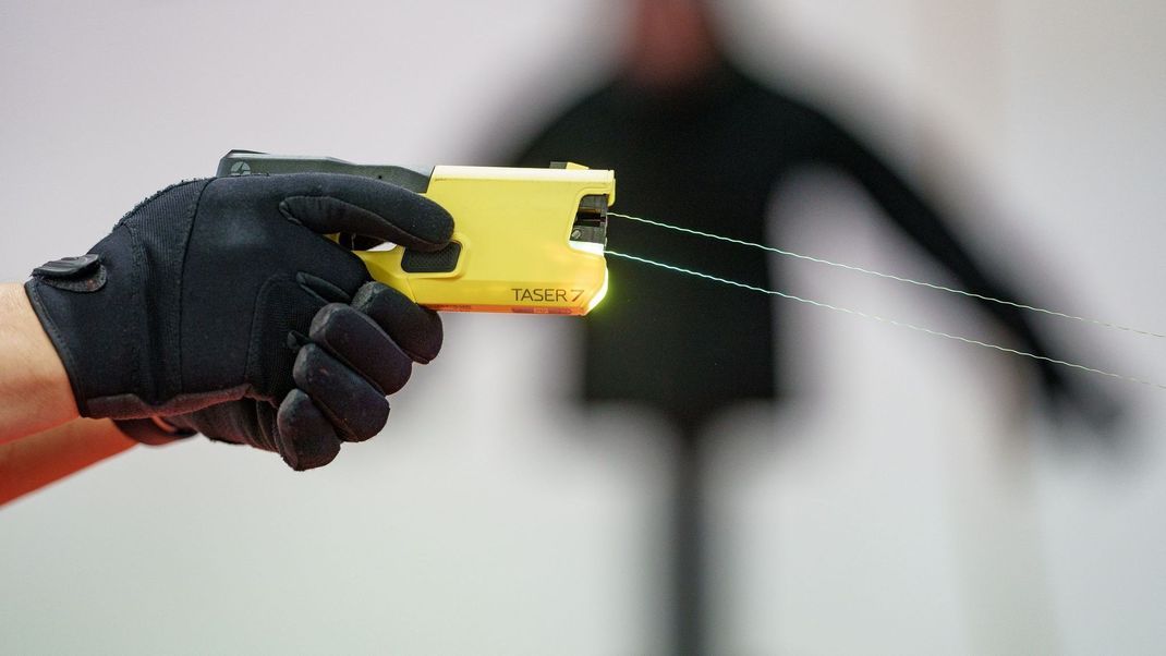 Ein Polizeibeamter demonstriert ein Distanz-Elektroimpulsgerät (DEIG oder auch Taser).