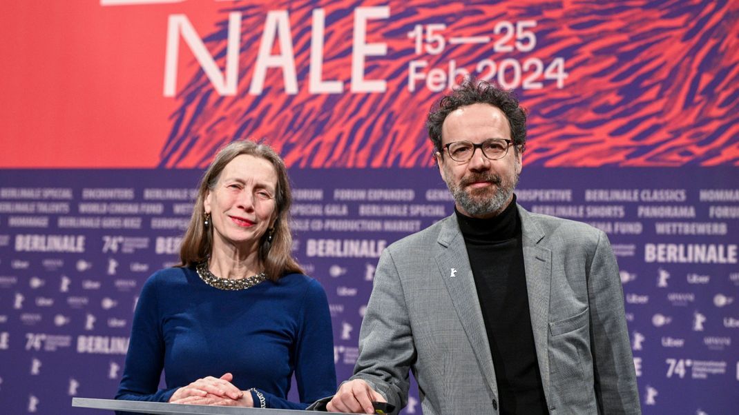Das Leitungs-Duo der Berlinale, Mariette Rissenbeek, Geschäftsführerin, und Carlo Chatrian, künstlerischer Direktor, stehen vor Beginn der Pressekonferenz zur Vorstellung der Bekanntgabe des Berlinale-Programms 2024 mit Merchandiseartikeln der Berlinale auf der Bühne.