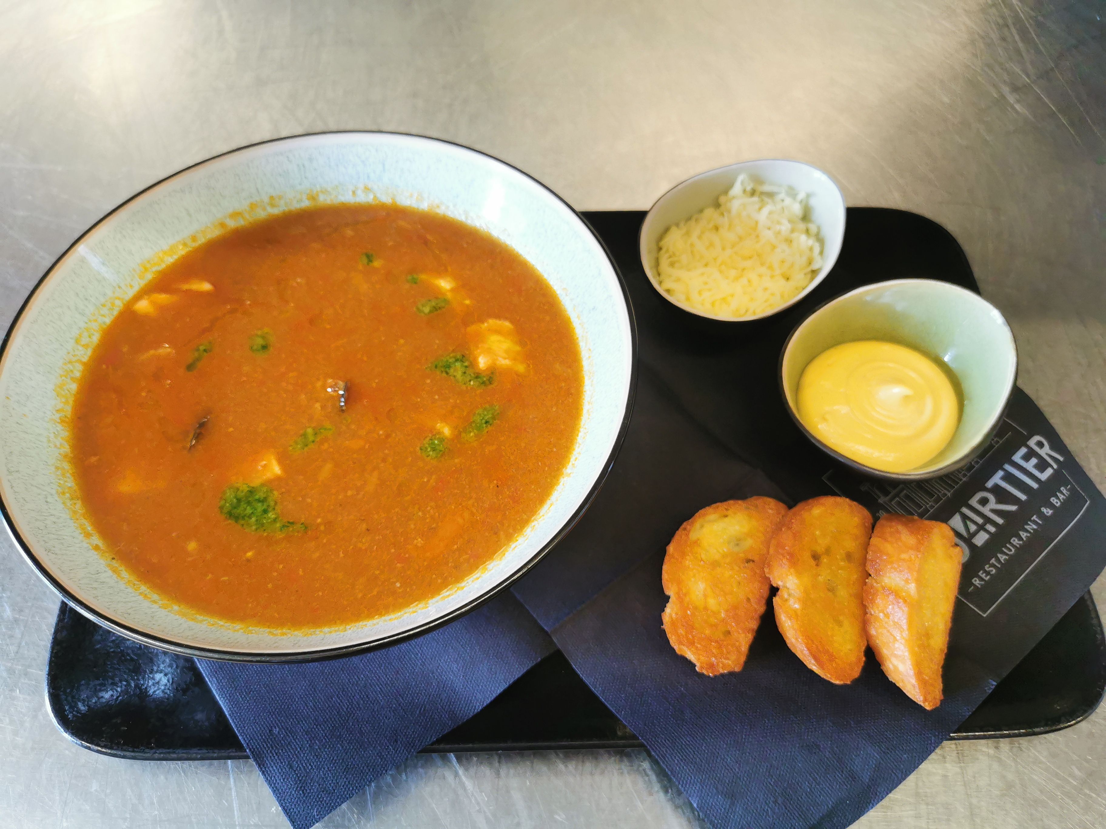 Bouillabaisse mit Edelfischen, geriebenem Käse und Röstbrot