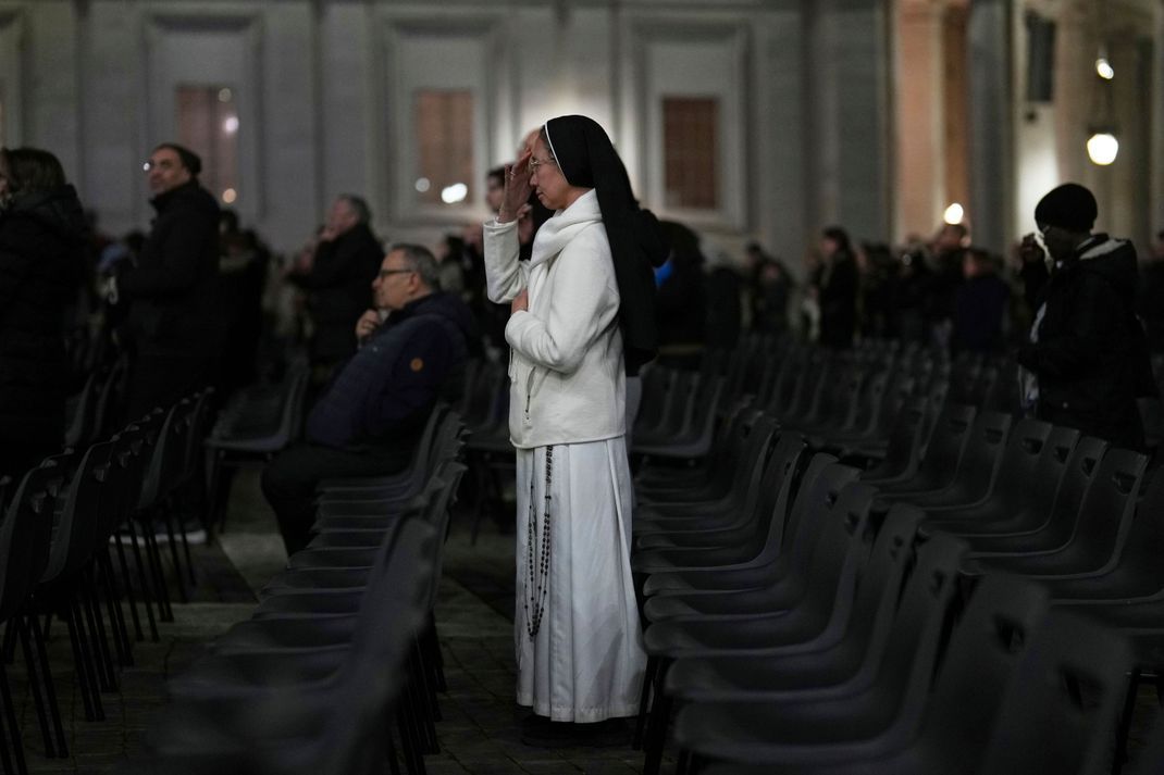 Eine katholische Nonne bekreuzigt sich während eines Rosenkranzgebetes für Papst Franziskus auf dem Petersplatz im Vatikan.