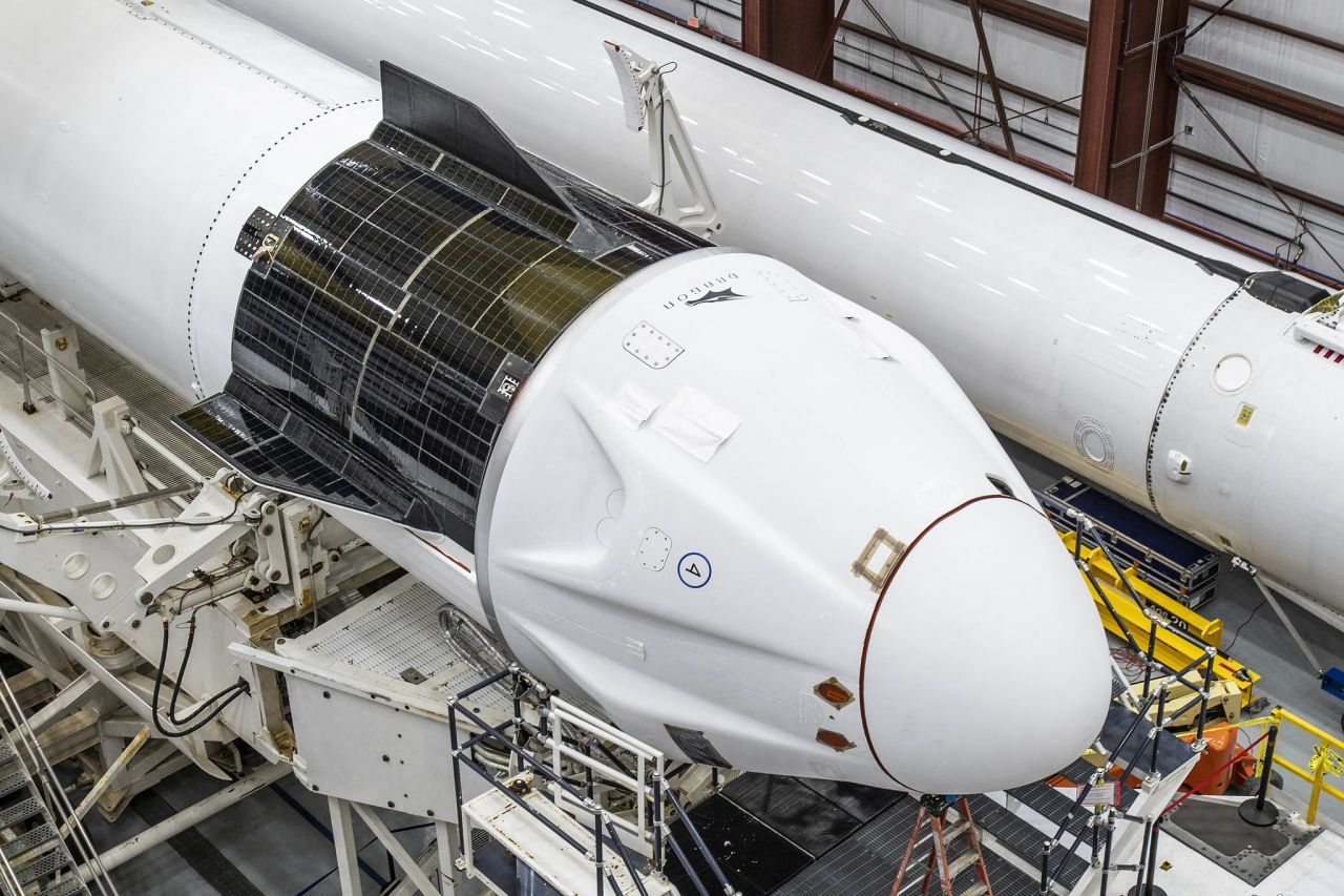 Noch unbenutzt: Der Crew Dragon, montiert auf eine Falcon 9-Rakete in der Montagehalle. In einem solchen Raumschiff wird auch der Deutsche Matthias Maurer starten. Im Bild gut zu erkennen: Die auf den unteren Teil angebrachten Solarpanelen, ein Kennzeichen der bemannten Version des Dragon.