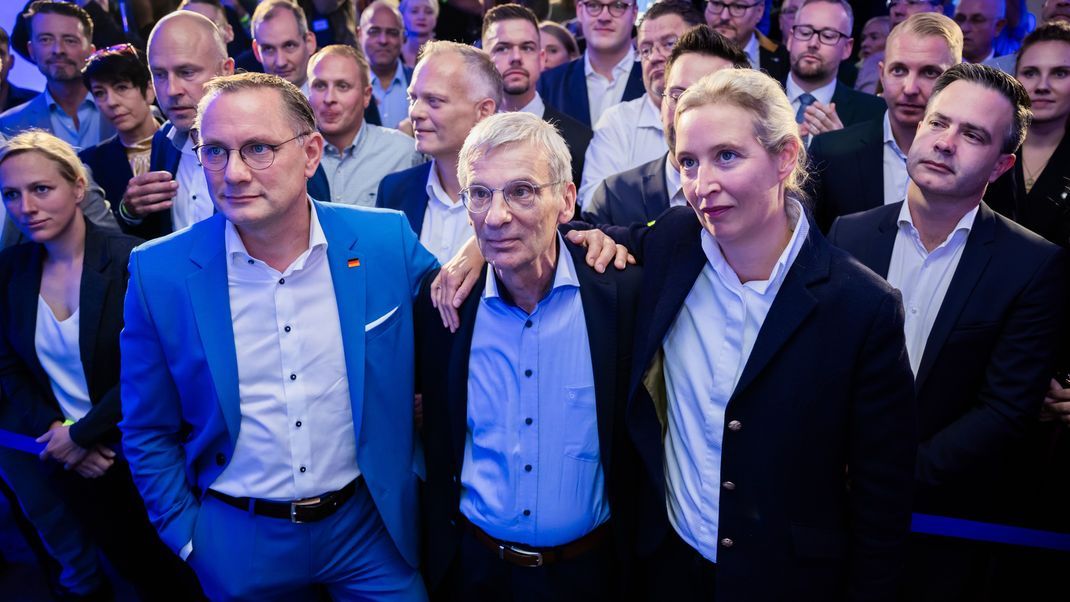 Tino Chrupalla (l-r), AfD-Bundessprecher, Hans-Christoph Berndt, stellvertetender Vorsitzender der AfD Brandenburg und Spitzenkandidat, und Alice Weidel, AfD-Bundessprecherin, stehen bei der Wahlparty der Brandenburger AfD in einem Gasthaus in Potsdam-Marquardt vor den ersten Hochrechnungen vor der Bühne.