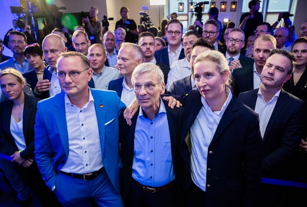 Tino Chrupalla (l-r), AfD-Bundessprecher, Hans-Christoph Berndt, stellvertetender Vorsitzender der AfD Brandenburg und Spitzenkandidat, und Alice Weidel, AfD-Bundessprecherin, stehen bei der Wahlparty der Brandenburger AfD in einem Gasthaus in Potsdam-Marquardt vor den ersten Hochrechnungen vor der Bühne.