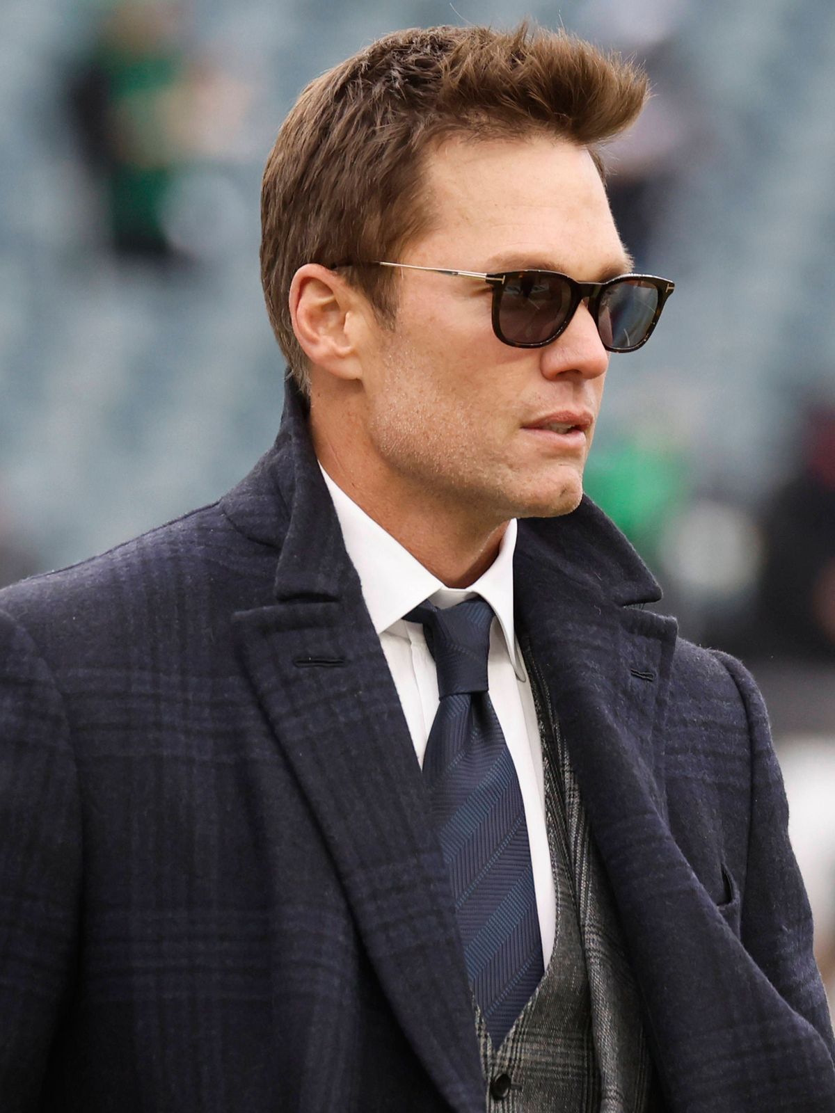 Tom Brady walks on the field before delivering television commentary for the NFC Championship Game between the Philadelphia Eagles and the Washington Commanders at Lincoln Financial Field in Philad...