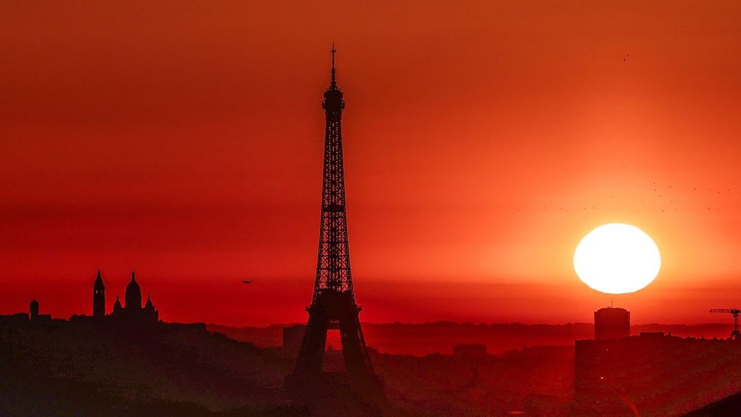 Die Sonne geht über dem Eiffelturm und der Basilika Sacre Coeur auf und löst - nicht nur visuell - Alarmstufe Rot in Paris aus.