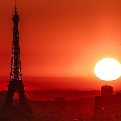 Die Sonne geht über dem Eiffelturm und der Basilika Sacre Coeur auf und löst - nicht nur visuell - Alarmstufe rot in Paris aus. 