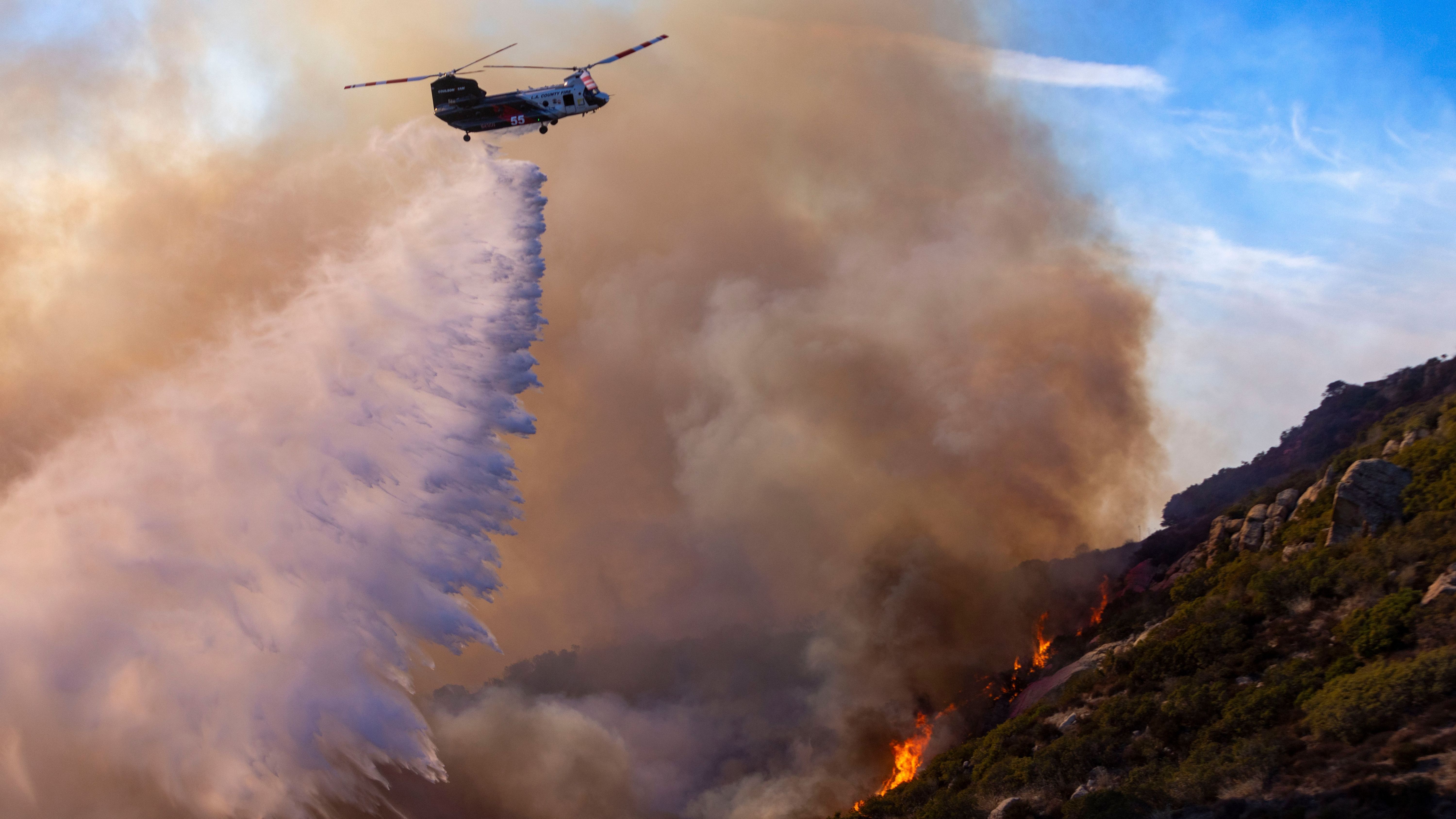 Ein Löschhubschrauber des Los Angeles County wirft Wasser auf das Franklin Fire, um Häuser an der nahe gelegenen Costa Del Sol in Malibu zu schützen.