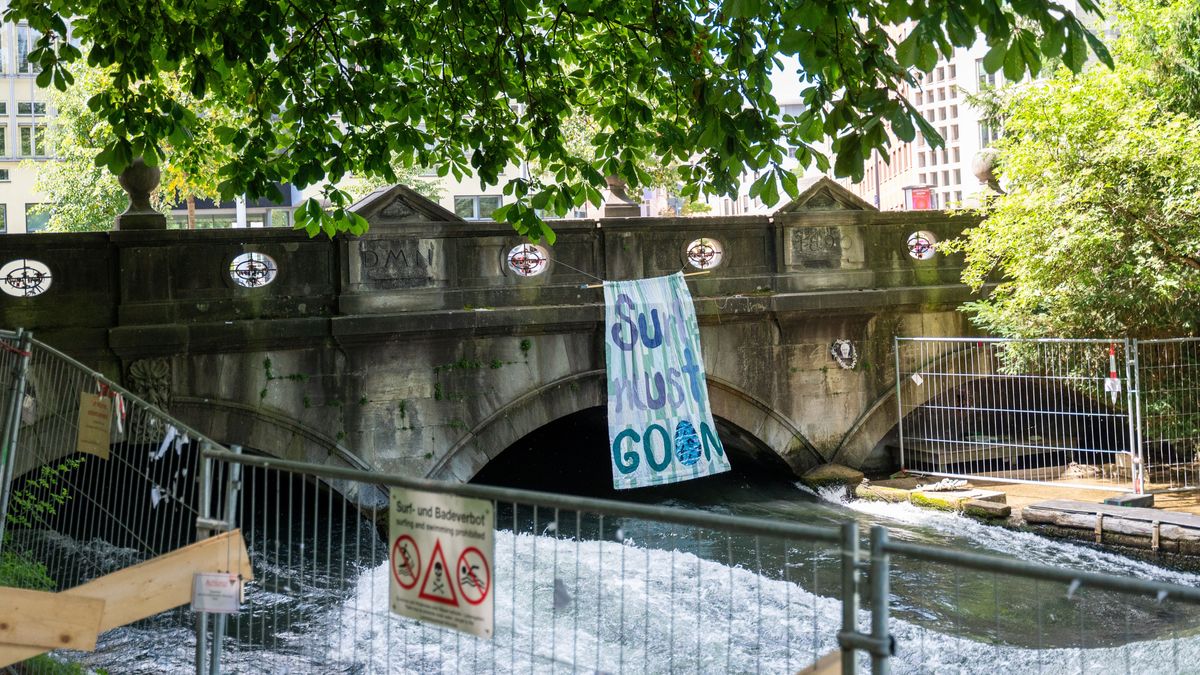 Ein Banner mit der Aufschrift «Surf must go on» hängt an der Eisbachbrücke an der Eisbachwelle.