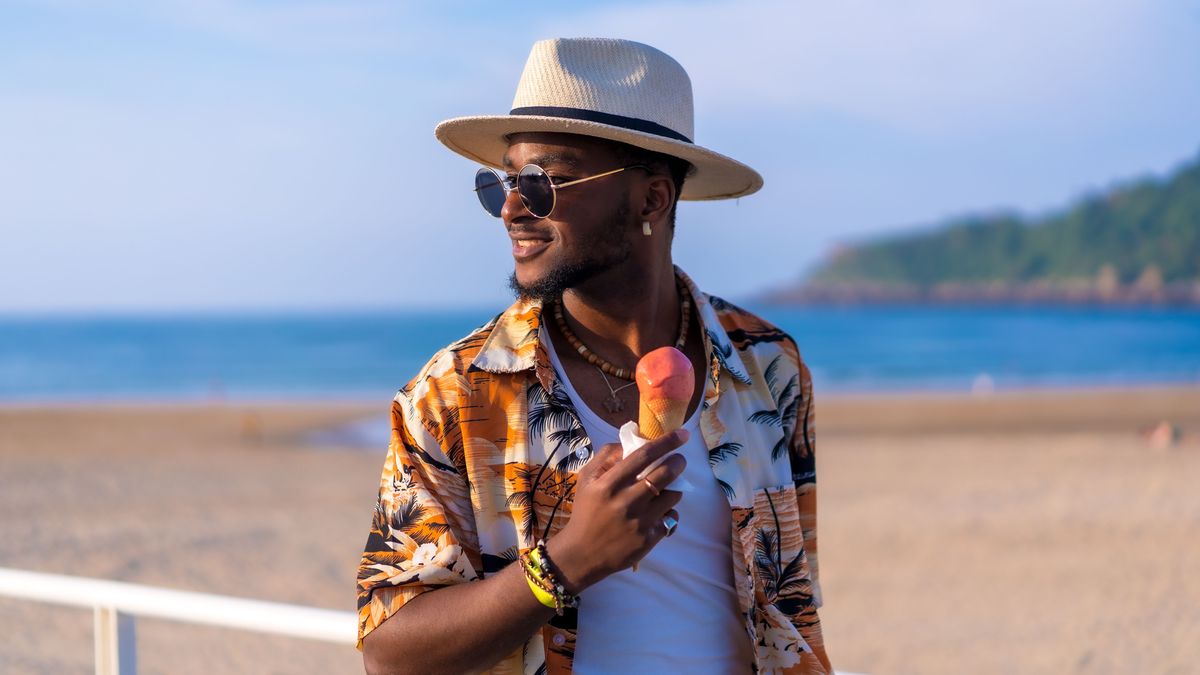 Mann mit Hut am Strand am Eis essen