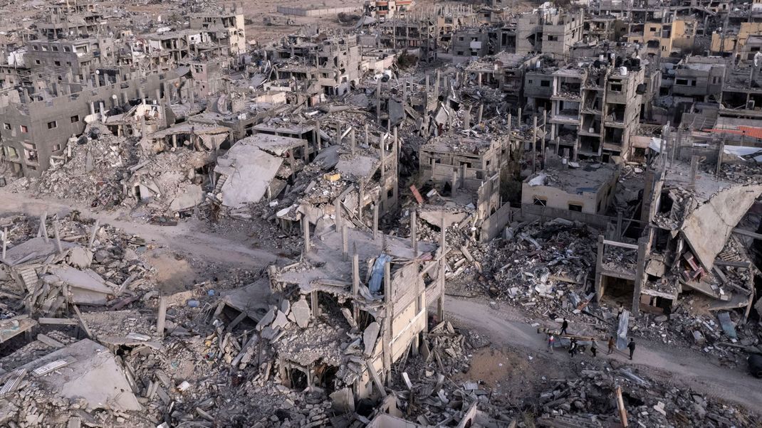 Ein von einer Drohne aufgenommenes Luftbild zeigt Palästinenser in der Ruinenlandschaft der Stadt Rafah im Süden des Gazastreifens. Sie wurde durch israelische Angriffe in Schutt und Asche gelegt. (Archivbild)