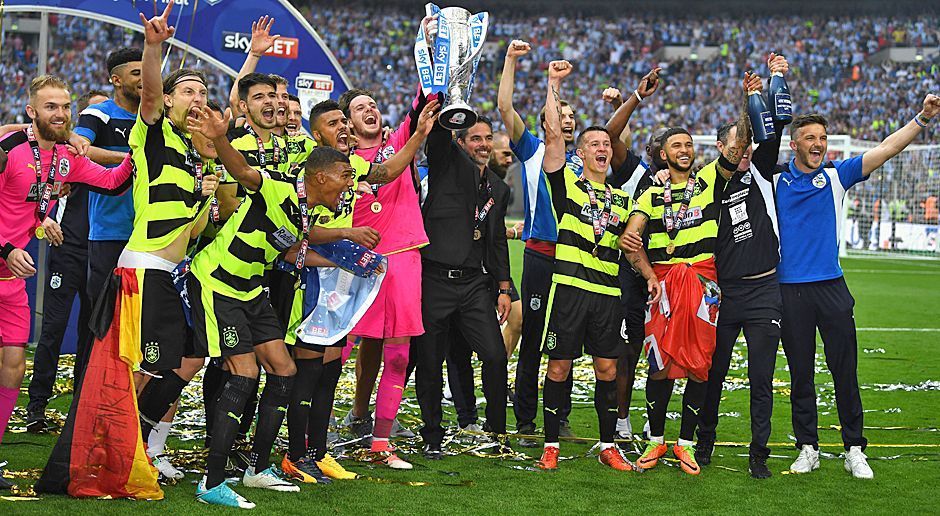 
                <strong>Huddersfield Town - der Aufstieg</strong><br>
                Huddersfield Town schafft das Wunder und steigt nach einem 4:3 (n.E.) gegen den FC Reading im Playoff-Finale in die Premier League auf! Der Klub ist damit erstmals seit 16.466 Tagen (45 Jahren!) erstklassig. Vor der Saison rechnete niemand mit der Truppe aus der 150.000-Einwohner-Stadt. Durch den Aufstieg sichern sich die sogenannten "Terriers" einen Bonus über rund 238 Millionen Euro. Zum Vergleich: Vor der Zweitliga-Saison wurde der Huddersfield-Etat auf 16 Millionen Euro geschätzt.
              