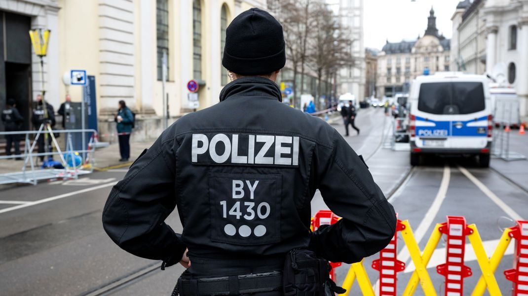 Polizisten regeln vor Beginn der Sicherheitskonferenz 2023 die Zufahrt zum Hotel Bayerischer Hof.