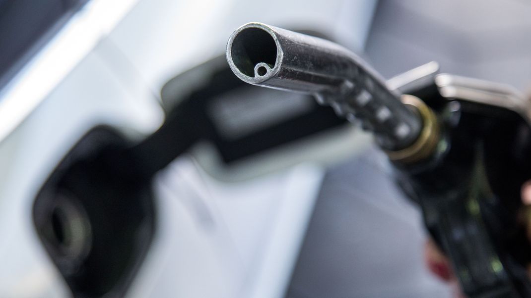 Ein Auto wird an einer Tankstelle betankt. 