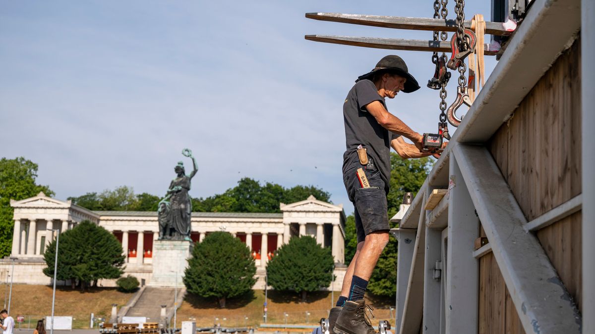 Arbeiter montieren in den frühen Morgenstunden große Einzelteile auf der Theresienwiese zusammen. 