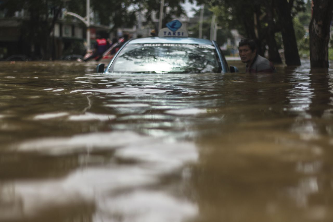 Ein Taxifahrer versuchte bei Überschwemmungen im Februar 2021, zu seinem Auto zu kommen.