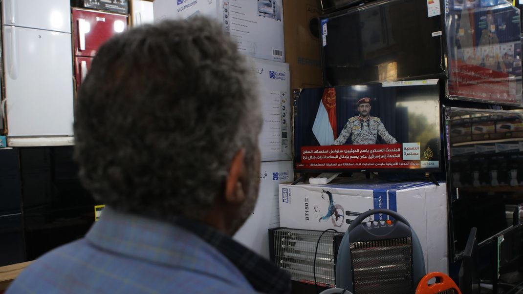 Nach dem Angriff auf einen Tanker sehen Jemeniten im Fernsehen eine Erklärung des Sprechers der Huthi-Rebellen.