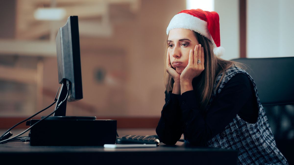 Unhappy Office Employee Working on Christmas Eve. Stressed entrepreneur spending time overworking during winter holidays