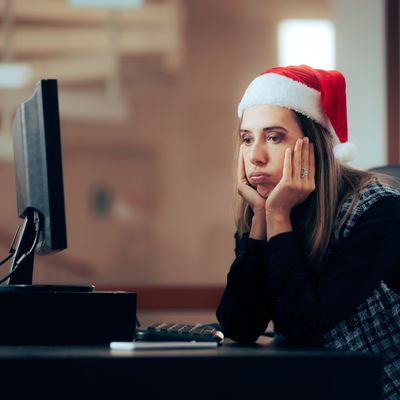 Unhappy Office Employee Working on Christmas Eve. Stressed entrepreneur spending time overworking during winter holidays