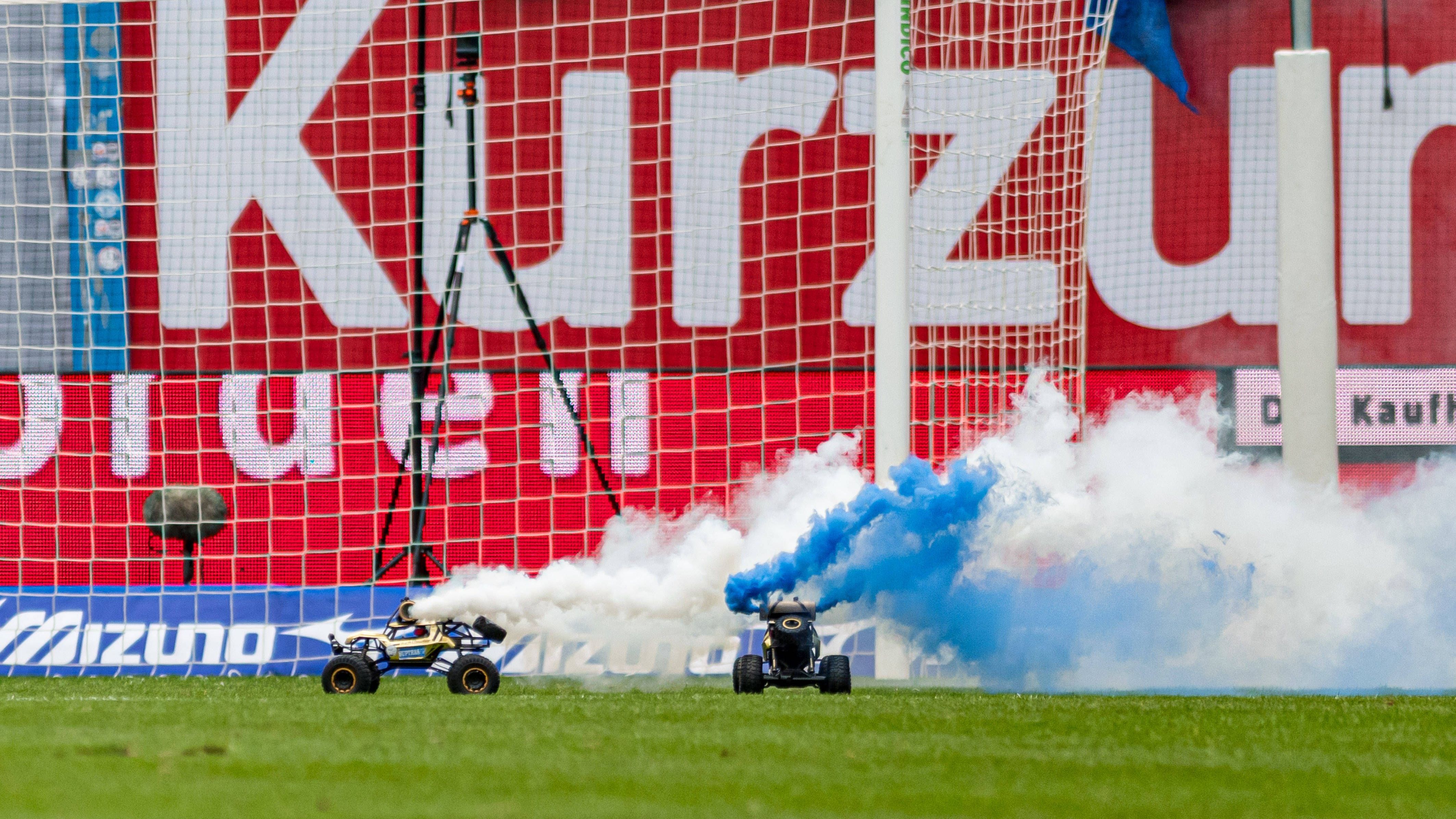 <strong>Ferngesteuerte Pyro-Autos in Rostock<br></strong>Ob sich die Rostocker da mit den Kölnern abgesprochen hatten? Auch im Ostseestadion fuhren nach rund zehn Minuten ferngesteuerte Autos über den Rasen, die Fans der "Kogge" hatten zudem noch Pyrotechnik an den Spielzeugen befestigt. Auf jeden Fall ein Hingucker, nach wenigen Augenblicken wurde die Partie gegen den HSV fortgesetzt.