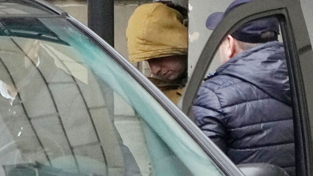 Evan Gershkovich, festgenommener US-Journalist, wird von russischen Beamten zu einem Bus eskortiert.