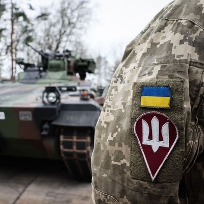 Ein ukrainischer Soldat steht vor einem Schützenpanzer Marder.