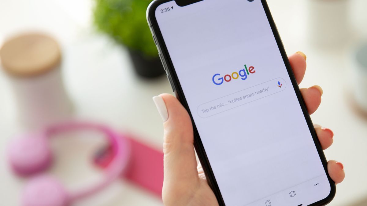 Woman holding iPhone X with social networking service Google 