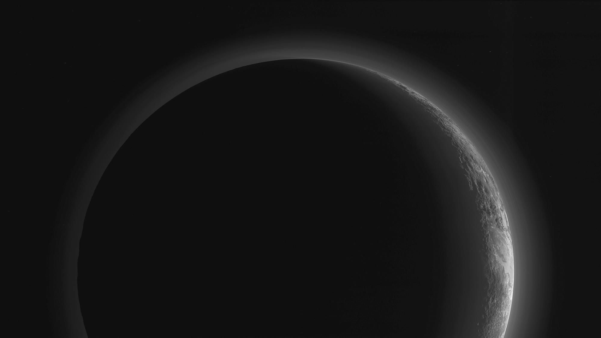 Eiskalt und nicht zu atmen: Von Plutos Nachtseite aus ist seine kalte und hauchdünne Stickstoff-Atmosphäre gegen die Sonne als diffuser Schleier zu sehen.