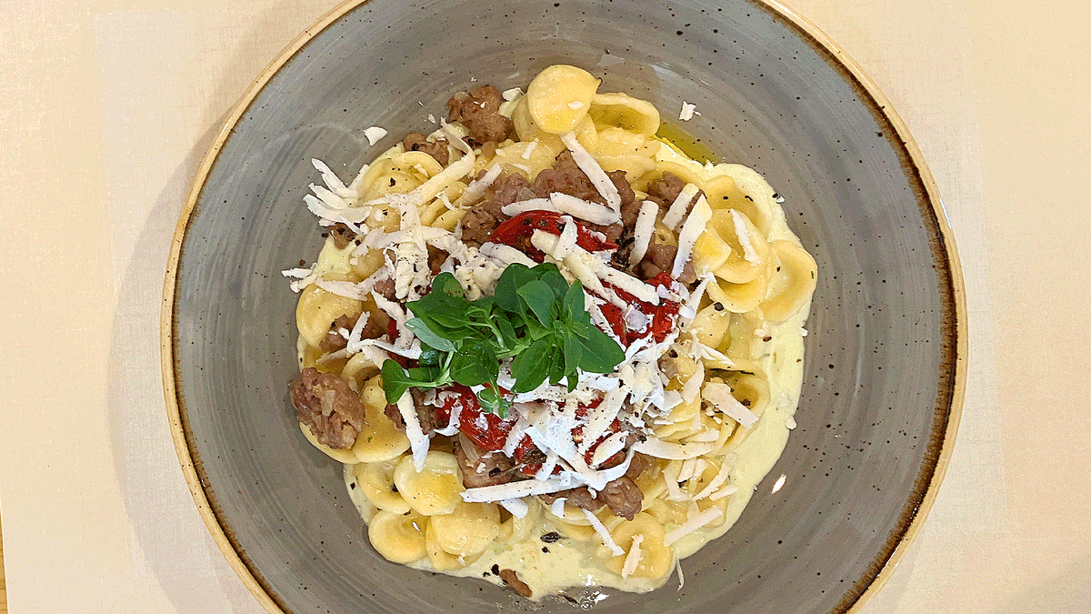 Orecchiette mit Salsiccia-Flocken, auf Burrata-Basilikum-Creme, kleines Tomaten-Confit und getrocknete salzige Ricotta-Späne