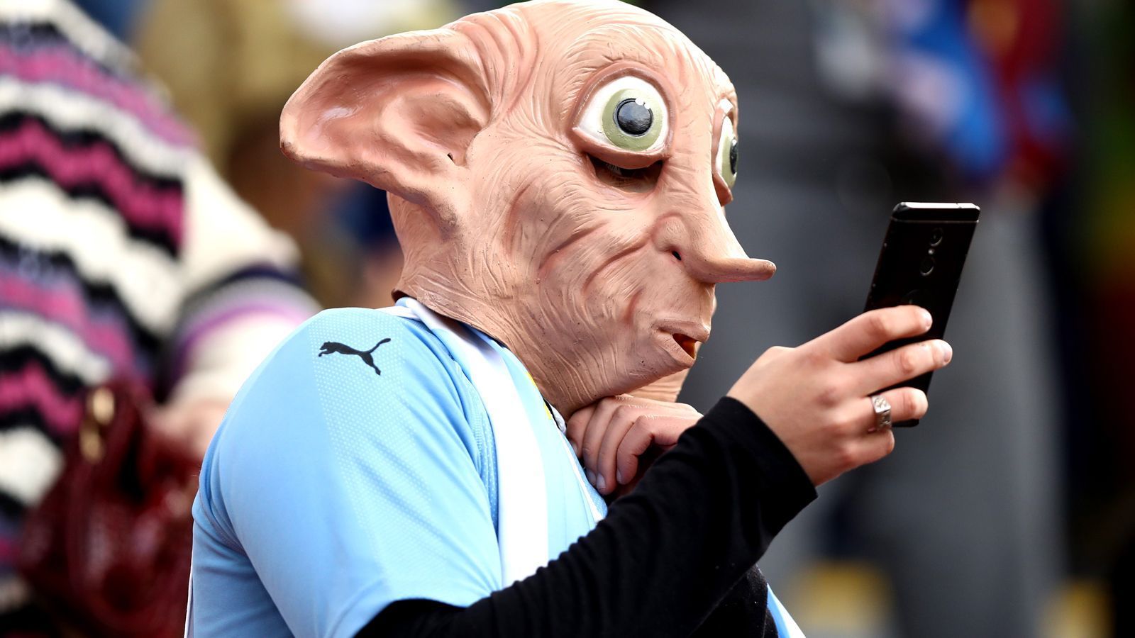 
                <strong>Fan aus Uruguay</strong><br>
                Zugegegebenermaßen: Was Hauself Dobby aus Harry Potter im russischen Stadion zu suchen hat, wissen wir auch nicht. Was wir aber sagen können: Der Fußball-Fan unter der Maske fiebert für Uruguay.
              