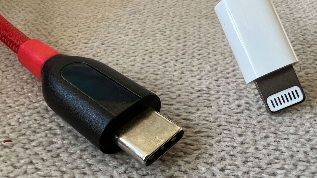 ARCHIV - 22.09.2021, Berlin: Ein rot-schwarzes Kabel mit einem USB-C-Stecker und ein Lightning-Stecker von Apple an einem weiÃen Kabel. Handys und zahlreiche andere ElektrogerÃ¤te mÃ¼ssen in der EU ab Mitte 2024 eine einheitliche Ladebuchse haben. UnterhÃ¤ndler der EU-Staaten und des Europaparlaments einigten sich auf USB-C als Standard-Ladebuchse. Foto: Christoph Dernbach/dpa +++ dpa-Bildfunk +++