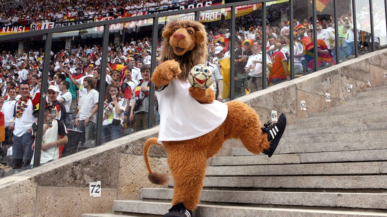 
                <strong>WM 2006 in Deutschland: Goleo VI. und Pille</strong><br>
                2006 in Deutschland waren dann der Löwe Goleo VI. und der sprechende Fußball Pille die Maskottchen des "Sommermärchens". Der Name Goleo beinhaltet mehrere Wortspiele wie das englische Wort für Tor ("Goal"), der spanische Ausruf ("Ole"), das englische Wort ("Go") und das lateinische Wort ("Leo"). Der Zusatz "der Sechste" sollte an das WM-Jahr 2006 erinnern. Größter Aufreger bei dem Maskottchen war, dass Goleo keine Hose trug.  
              