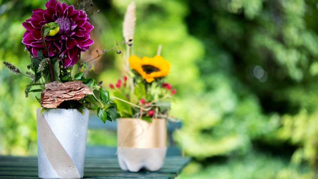 DIY-Blumenvasen aus Beton sind ein minimalistisches Highlight auf dem Gartentisch.