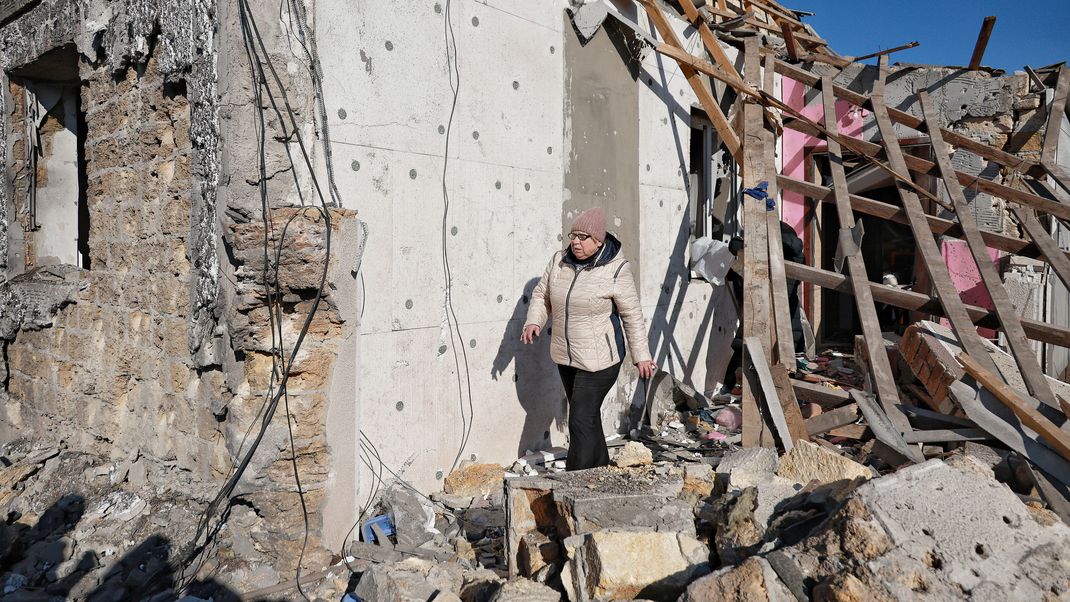 Eine Frau geht an einem Haus entlang, das durch einen russischen Raketenangriff in der Region Odessa im Süden der Ukraine zerstört wurde.