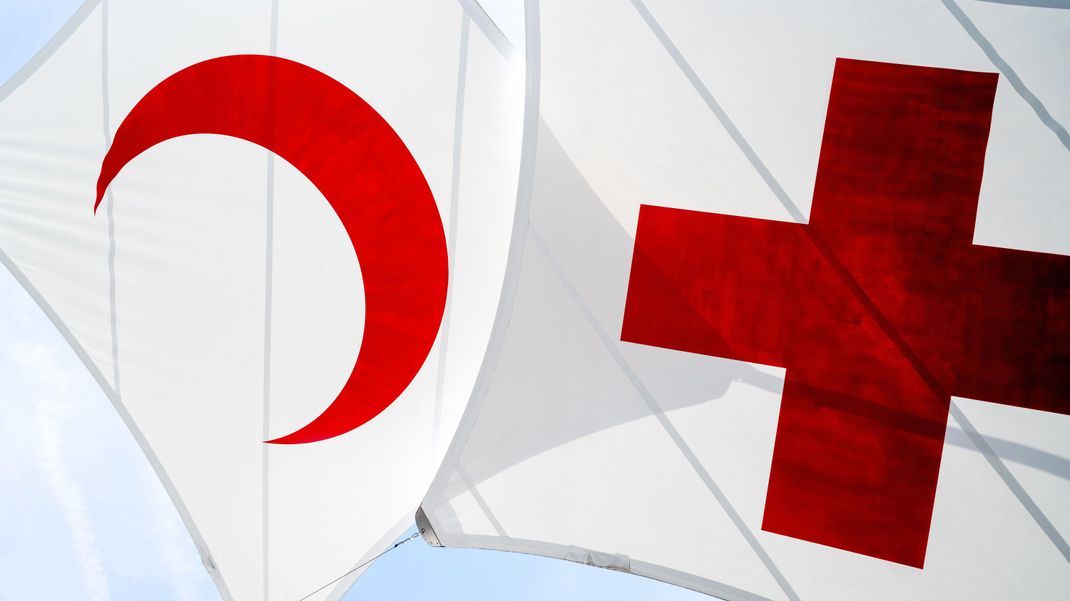Die namensgebenden Symbole der internationales Rotkreuz- und Rothalbmondbewegung: das rote Kreuz und der rote Halbmond auf weißem Hintergrund.