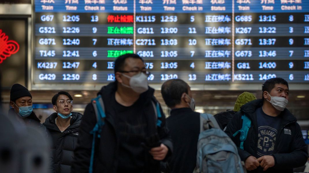 Reisende gehen in Peking durch die Bahnhofshalle des Westbahnhofs.