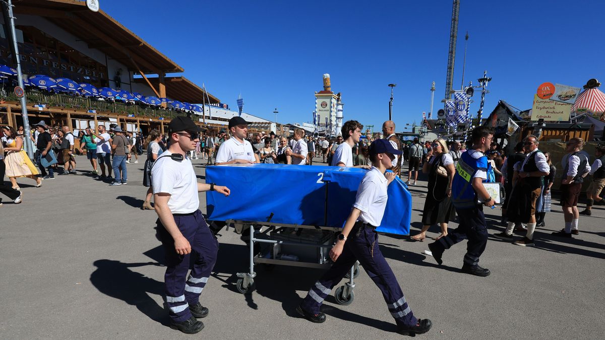 Mitarbeiter der Oktoberfest-Ambulanz gehen am ersten Tag des Oktoberfestes über das Festgelände.