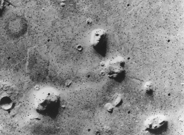 Im Juli 1976 wurde von NASA's Viking 1 dieses Bild aufgenommen. Es scheint so, als wäre ein Gesicht darauf zu erkennen. Bei den schwarzen Punkten handelt es sich um Fehler bei der Bildübertragung.