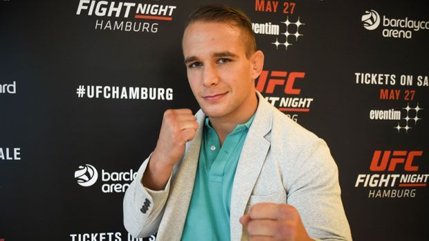 
                <strong>Nick Hein</strong><br>
                Nick Hein ("Sergeant"): Im Mai noch musste der beste deutsche MMA-Kämpfer, Nick Hein, seinen geplanten Auftritt bei der UFC Fight Night in Rotterdam wegen eines schweren Bandscheibenvorfalls absagen. Dass er in Hamburg schon wieder ins Octagon steigen kann, grenzt an ein medizinisches Wunder. Der Ex-Polizist bereitete sich jedoch ein wenig anders als gewöhnlich vor. Neben Ring- und Kickboxtraining standen auch viele Stunden Physiotherapie auf dem Trainingsplan.
              