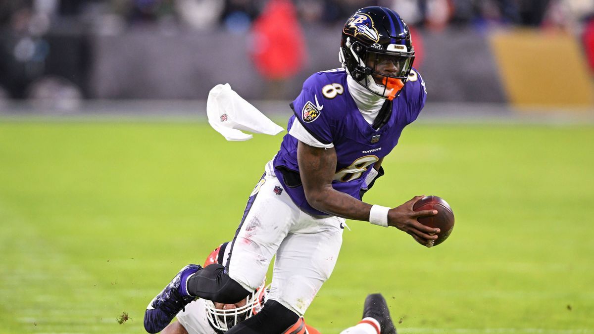 Baltimore Ravens quarterback Lamar Jackson (8) loses his towel on a seven-yard gain against Cleveland Browns defensive end Ogbo Okoronkwo (54) during the first quarter at M&T Bank Stadium in Baltim...